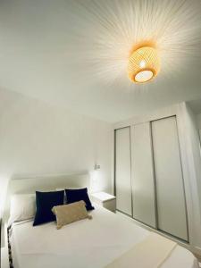 大加那利岛拉斯帕尔马斯Acogedor y cómodo apartamento con piscina的卧室配有白色大床和光线