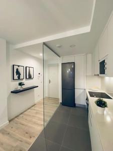 大加那利岛拉斯帕尔马斯Acogedor y cómodo apartamento con piscina的一间白色的大厨房,里面装着蓝色的门