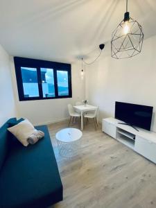 大加那利岛拉斯帕尔马斯Acogedor y cómodo apartamento con piscina的客厅配有沙发和桌子