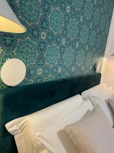 博洛尼亚Tecnopolo Fiera Suite的一间卧室设有一面墙,配有绿色和白色的壁纸