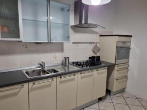 阿佐诺圣保罗SWEET HOME的厨房配有白色橱柜、水槽和冰箱。