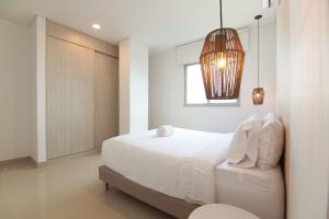 卡塔赫纳Wynwood Las Flores in Cartagena的卧室配有白色的床和窗户。