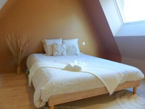 埃夫勒Le Green Cosy的一间卧室配有一张带白色床单的床和一扇窗户。