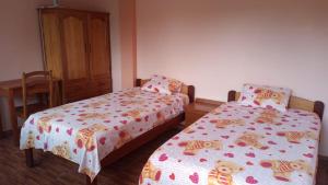 SauceHospedaje Franco-Peruano El Tambito的一间卧室配有两张床、一张桌子和一个橱柜