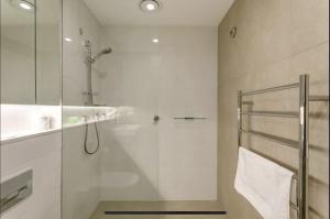 悉尼Lovely One Bedroom + Study with Infinity Pool的一间带玻璃淋浴和水槽的浴室
