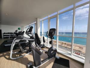 奥拉涅斯塔德ARUBA DREAM GETAWAY 2BR/2BT OCEAN & POOL VIEW的健身房设有心肺功能训练器材和大窗户