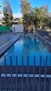 普孔Departamento en pucon的蓝色海水游泳池和围栏