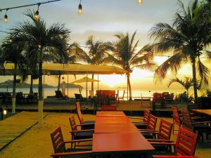 普拉亚弗拉明戈Hotel Tabasco的海滩上的一组桌椅,享有日落美景