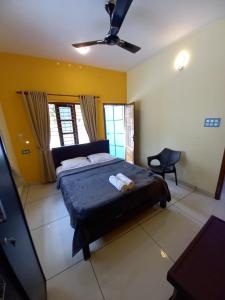 瓦尔卡拉Madhav Mansion Beach Resort的一间卧室配有一张床和吊扇
