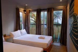 卢纳将军城Lubihan Siargao的一间卧室设有两张床和一个美景窗户。