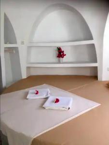 特鲁卡那拉特Villa Dreamdome的一张白色桌子,上面有两把餐巾纸和鲜花