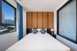 岘港Señorita Boutique Hotel的一间卧室设有一张床和两个窗户。