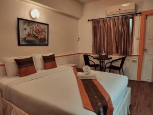 合艾亚细亚大酒店的酒店客房设有两张床、一张桌子和一个窗户。