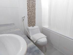 合艾梅林大酒店的白色的浴室设有卫生间和水槽。