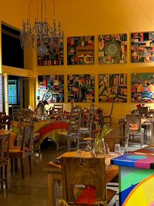坦加拉Buckingham Place的餐厅设有桌椅,墙上挂有绘画作品