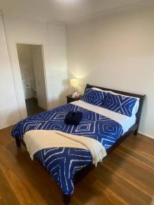 悉尼Lovely 2 bedroom apartment with city views的卧室配有一张床,上面放着一只猫