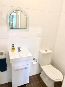 悉尼Lovely 2 bedroom apartment with city views的白色的浴室设有卫生间和水槽。