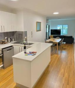 悉尼Lovely 2 bedroom apartment with city views的厨房以及带白色台面的客厅。