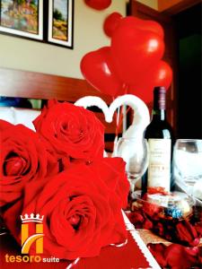 塔克纳Tesoro Suite的一张红玫瑰桌和一瓶葡萄酒及气球