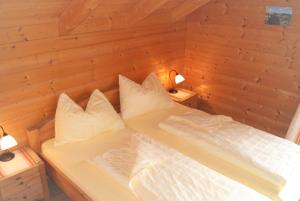 PöllaubergFerienhaus mit Panoramaausblick und Sauna - 3 SZ的木制客房的一张床位,配有两个枕头