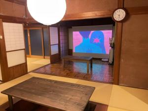 ŌbeShozu no Yado Hamakaze - Vacation STAY 37514v的一间设有大屏幕、桌子和时钟的房间