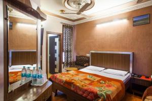 贾姆穆Hotel Novelty的一间卧室配有一张床和一张带瓶装水的书桌。