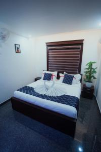 瓦亚纳德BEVERLY SUITES的一间卧室配有一张大床和木制床头板