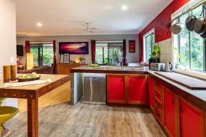 阿格奈什沃特KiteSurf 1770 Beach House的厨房配有红色橱柜和木桌