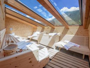 迈尔霍芬Apart Central – Premium Mountain&Garden的一间设有白色椅子和大窗户的桑拿浴室