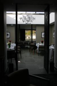 Marigny-Saint-Marcel布兰科酒店的一间设有白色桌子和吊灯的用餐室