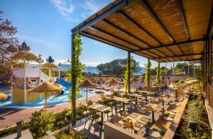 斯塔里格勒Valamar Amicor Green Resort的度假村的户外庭院配有桌子和遮阳伞。