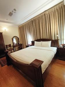 多哈艾卡瑞斯酒店的一间卧室配有一张带白色床单的大床