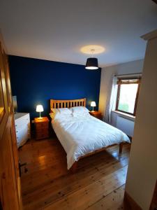 凯尔西温Picturesque Riverside Home的一间卧室配有一张蓝色墙壁的床
