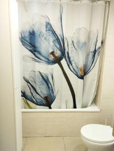 帕拉莫斯Cozy flat with terrace的浴室设有蓝色花卉的浴帘
