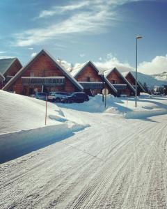 德沃吕伊Chalet La joue du Loup的地面和建筑上积雪的滑雪小屋