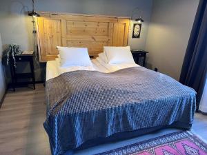 艾尔夫达伦流域酒店的一间卧室配有一张大床和木制床头板