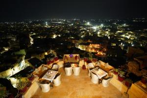 斋沙默尔Hotel The Surya Jaisalmer的享有夜间城市美景,配有桌椅