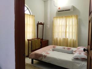 怡保Homestay YatiMizi (Bungalow Station 18, Ipoh)的一间卧室配有一张床、镜子和窗户