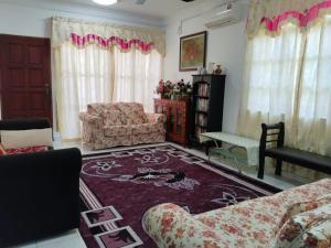 怡保Homestay YatiMizi (Bungalow Station 18, Ipoh)的客厅配有沙发、椅子和地毯