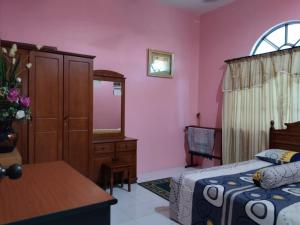 怡保Homestay YatiMizi (Bungalow Station 18, Ipoh)的一间卧室配有一张床、梳妆台和镜子