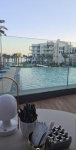 富查伊拉Luxury sea view Apartment In Address Hotel Fujairah的餐桌,带碗食物,享有游泳池的景色