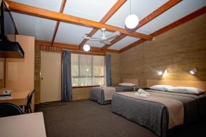 Hopetoun河普汤汽车旅馆的客房设有两张床、一张桌子和一个窗户。