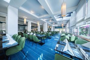 比奥格勒·纳·莫鲁科纳提酒店的用餐室配有桌子和绿色椅子