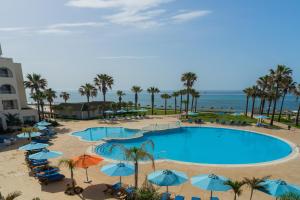 纳布勒Khayam Garden Beach Resort & Spa的享有带遮阳伞的游泳池和海滩的空中景致