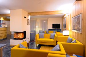 库马约尔艾格勒酒店的客厅设有黄色的沙发和壁炉