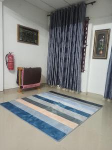 日得拉Rizqy Homestay di Jitra的一间铺有蓝色和白色地毯的客房