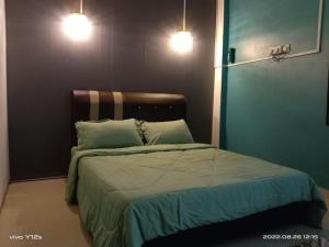 日得拉Rizqy Homestay di Jitra的一间卧室配有带2个枕头和2盏灯的床