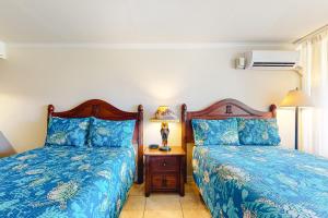 卡帕阿Islander on the Beach 370的一间卧室配有两张床和一张带台灯的桌子