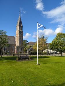 RhynieLottie’s Cottage, Rhynie, Aberdeenshire的教堂前方的旗帜