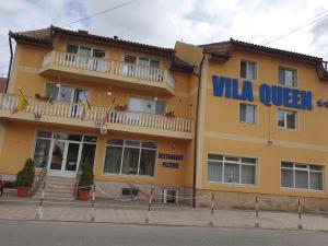 阿拉德Vila Queen的黄色的建筑,上面标有读别墅大号床的标志